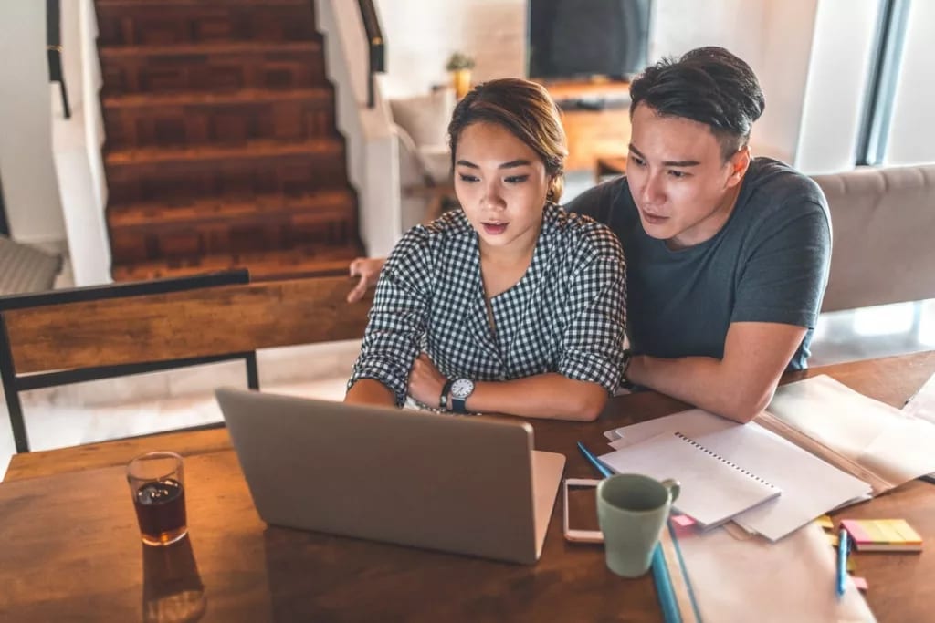 Young couple at table with laptop bLGhsGN.width iGaUKue.jpg