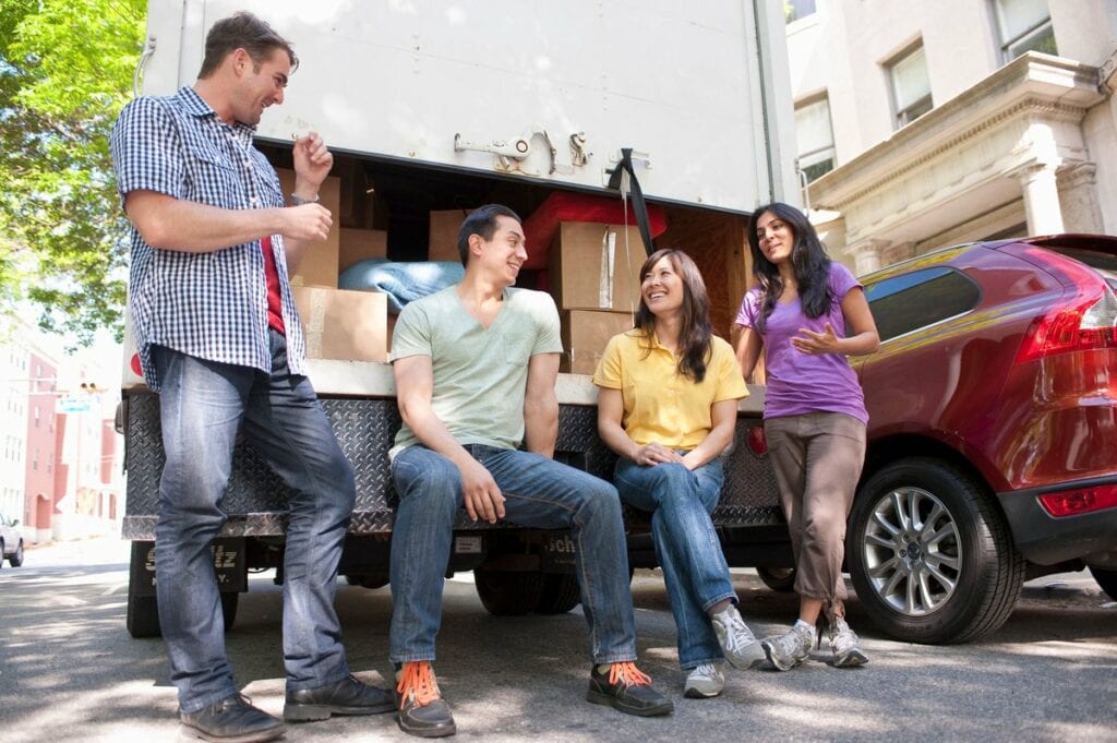 Four adults hanging out by loaded moving truc.width LAOTj.jpg