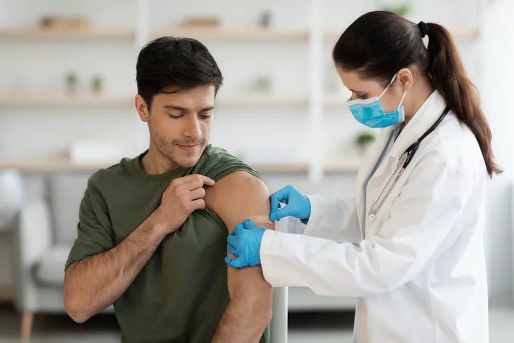 Healthcare worker putting bandaid over vaccin.width .jpg