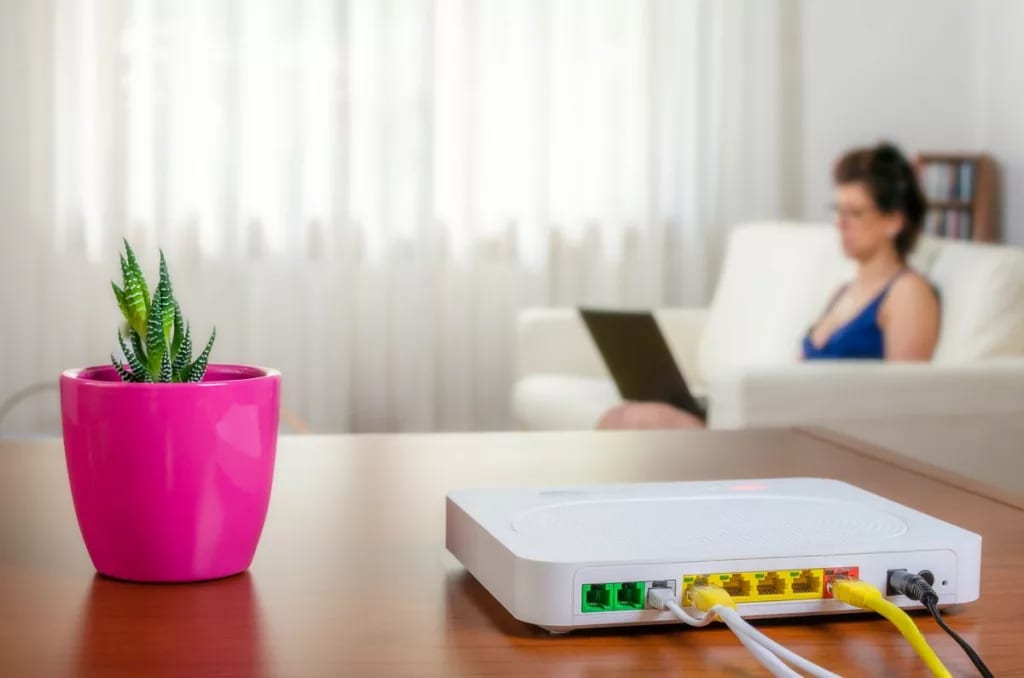 Internet router in foreground with woman usin.width VDwzYv.jpg