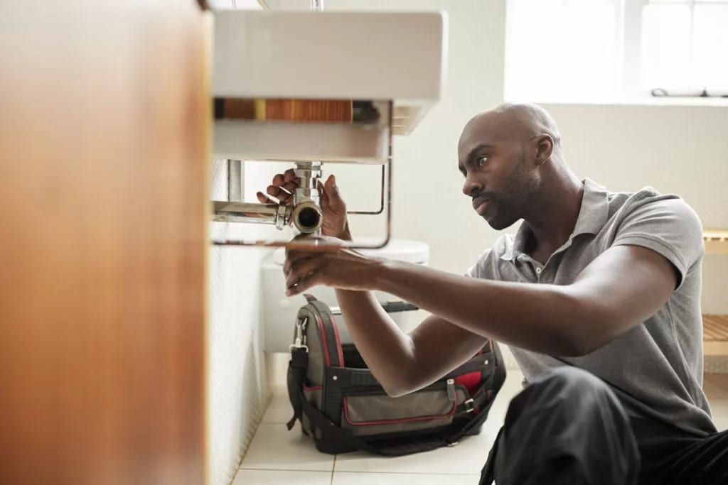Man fixing plumbing under sink HIULjzU.width .jpg