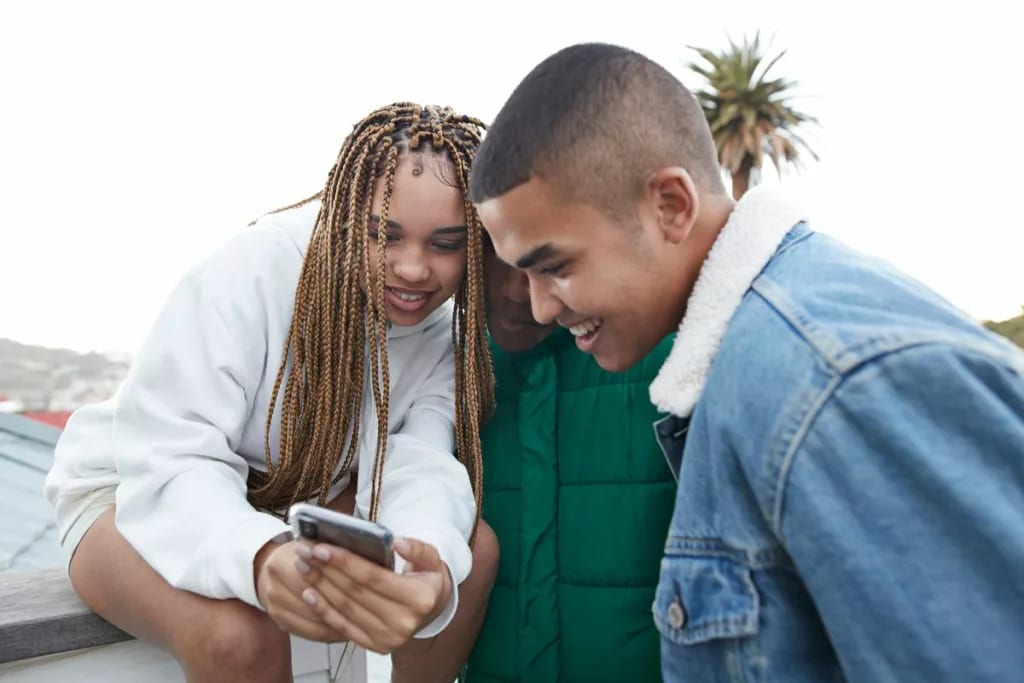 three people looking at phone PkLfKJi.width .jpg