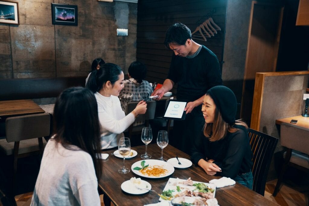 woman handing waiter credit card CDOCLp.width .jpg