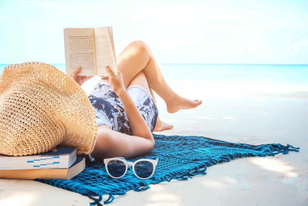 woman reading book on the beach GettyImages .width SivqfJ.jpg