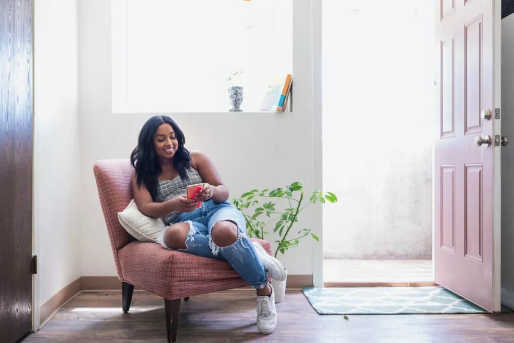 young adult holding phone in chair ZcjAQ.width .jpg