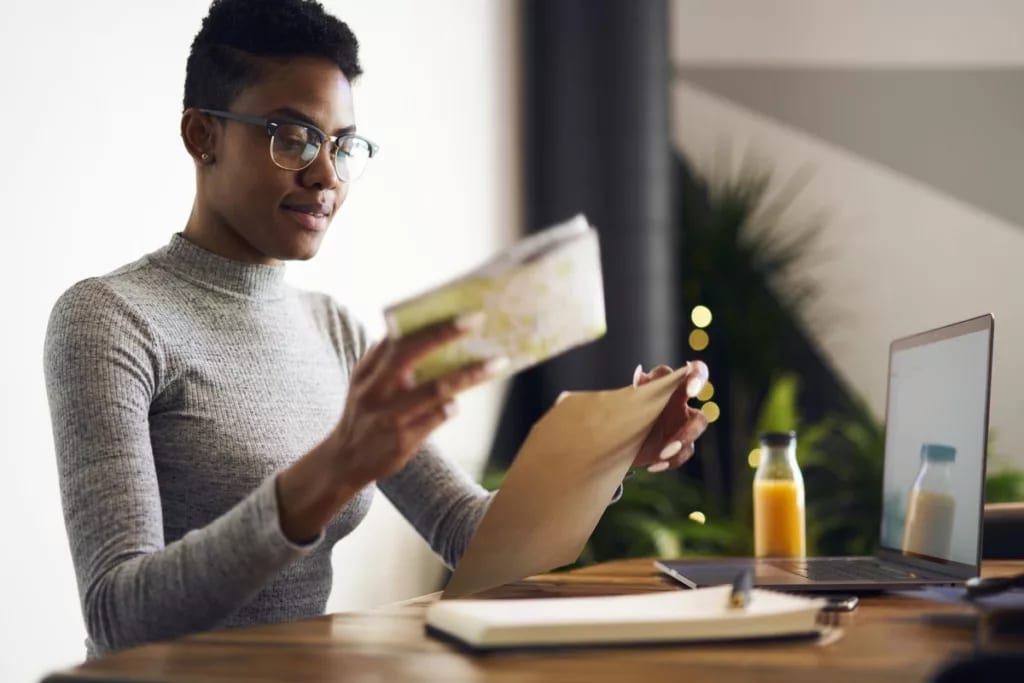 Woman with paperwork and laptop.width .jpg