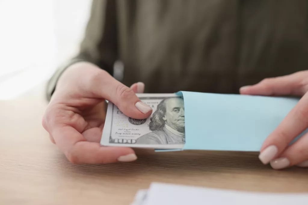 hands opening envelope with cash pYhHcb.width .jpg