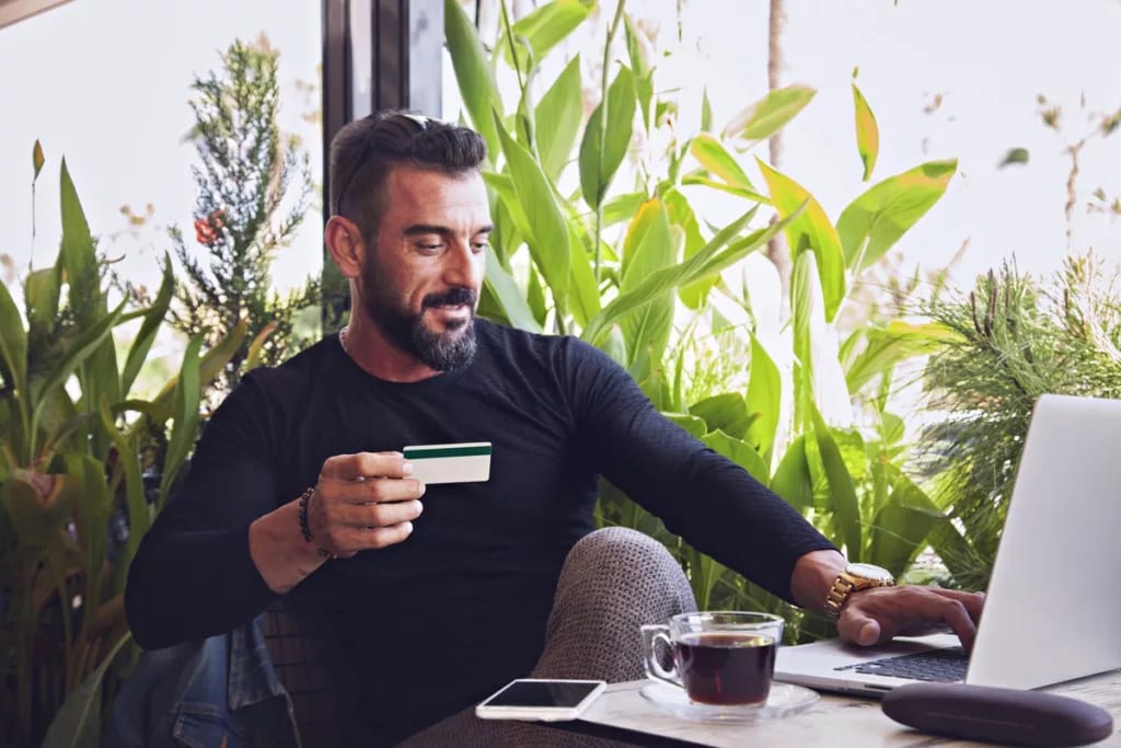 man in cafe with credit card and laptop.width .jpg