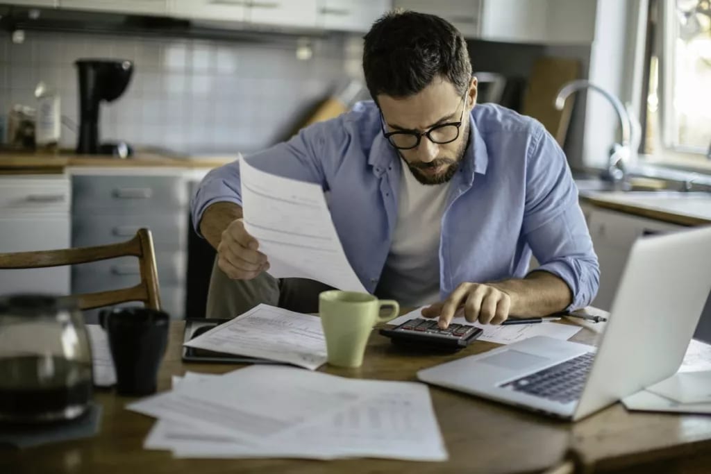 man with calculator and bills byFeor.width .jpg