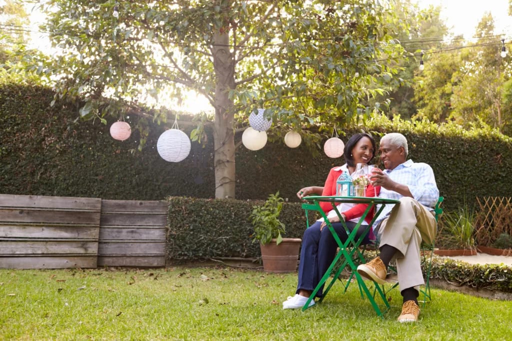 mature couple relaxing drinking wine together in their backyard.jpg
