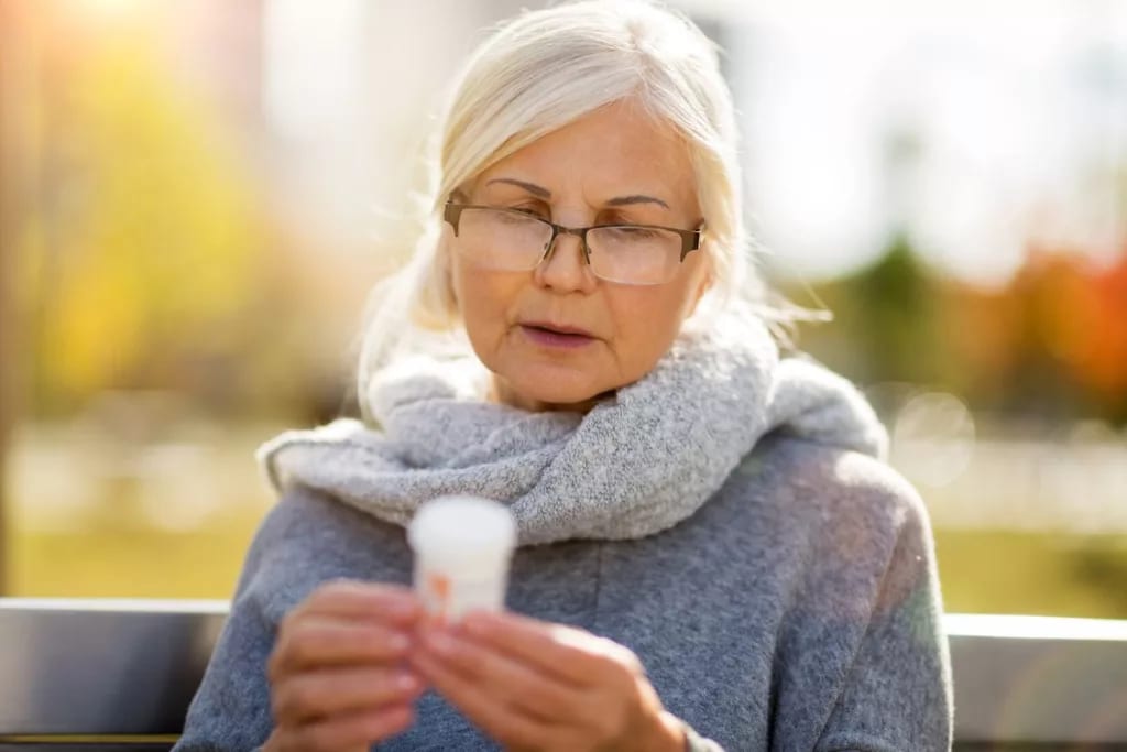 older woman reading pill bottle.width .jpg