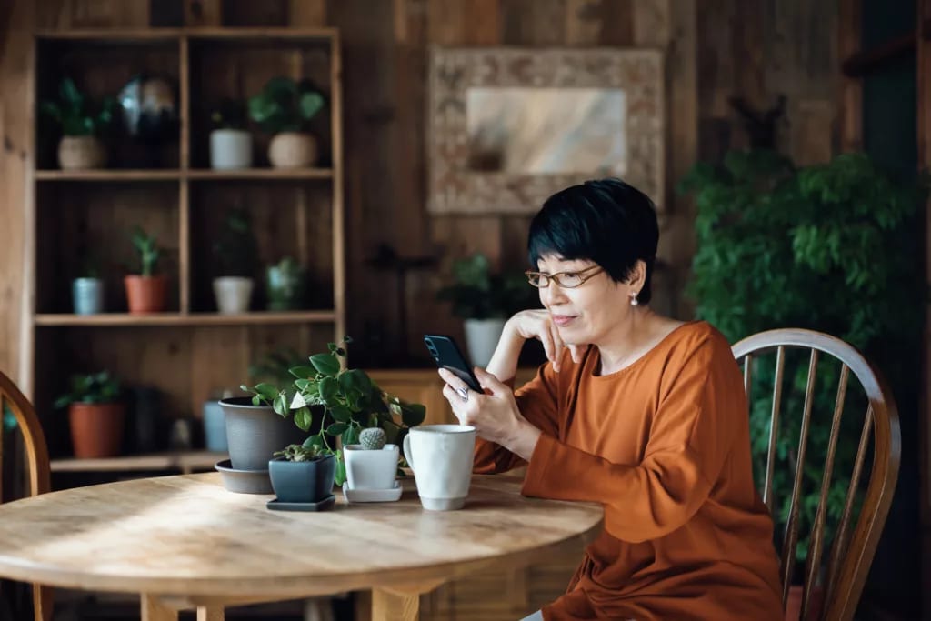 person sitting at a table using a smartphone.jpg