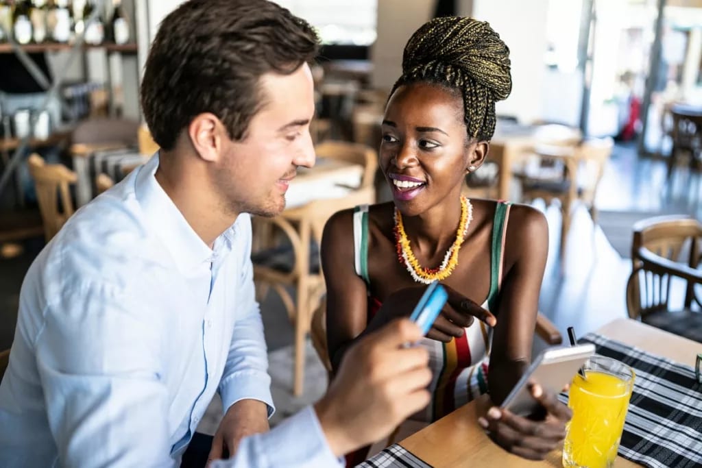 Couple has card out to pay in a restaurant. u.width .jpg