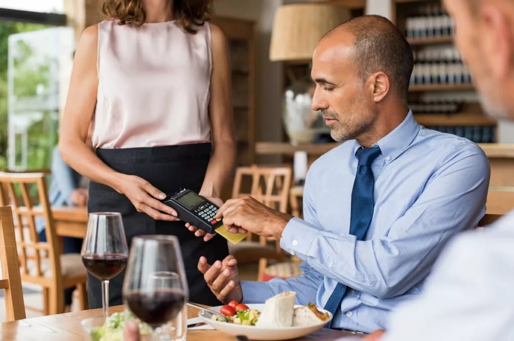 Man swiping credit card at restaurant JoiRpPu.width .jpg