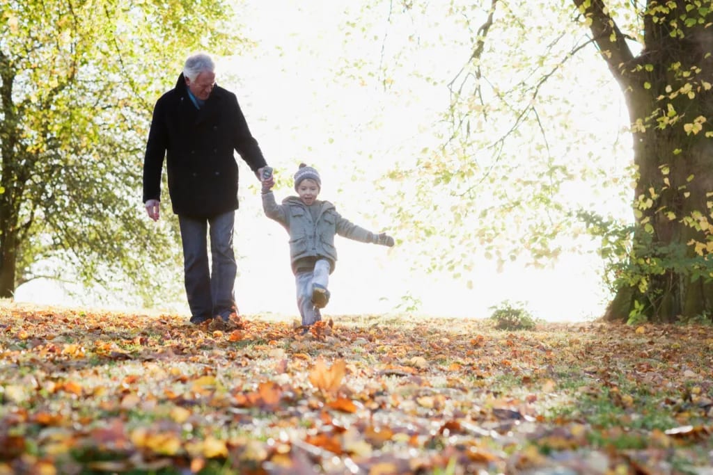 grandad grandkid kicking leaves.jpg
