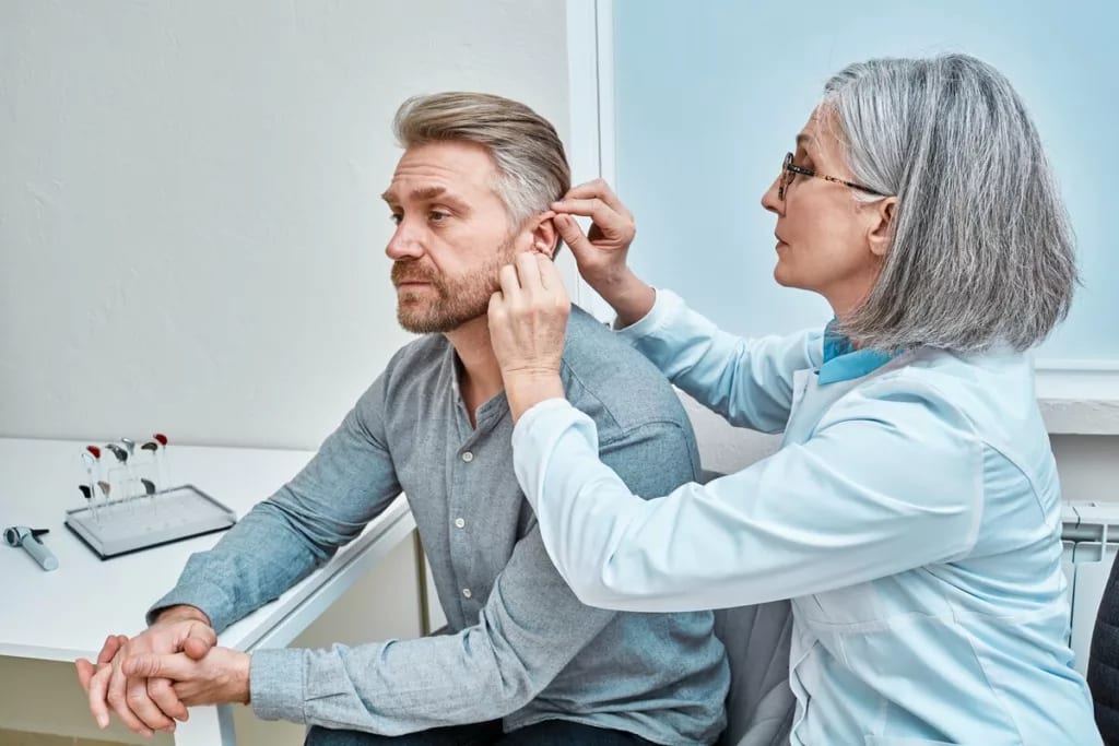 Mature person being fitted for hearing aids. .width .jpg