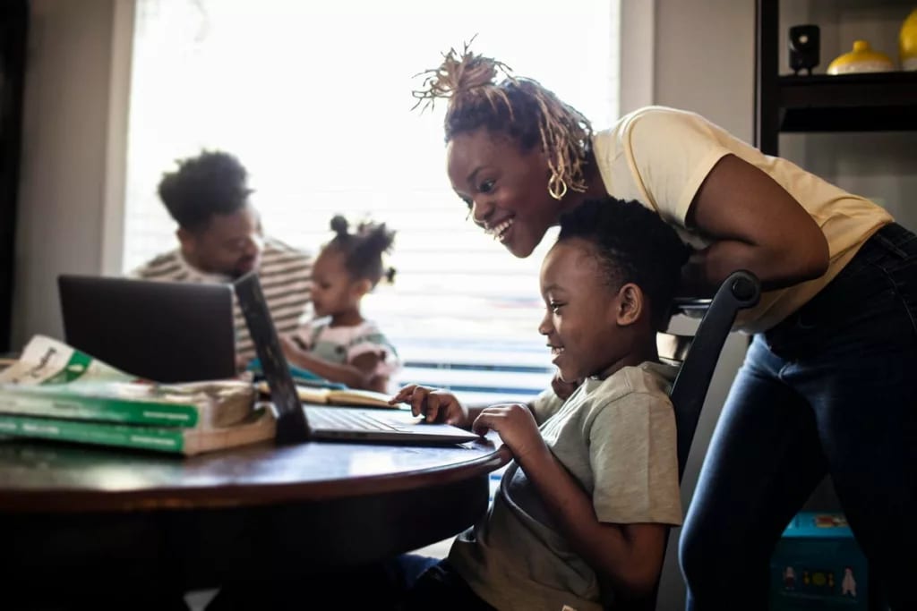 Mother helping young child with e learning on.width jYiYcn.jpg