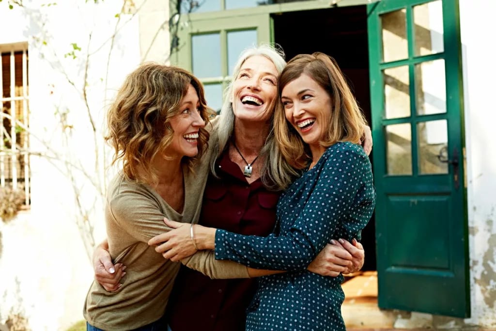 Two middle aged people hug an older matriarch.width .jpg