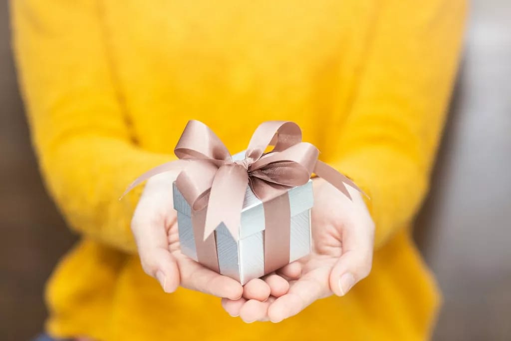 Woman holding small gift BHDbAvx.width .jpg