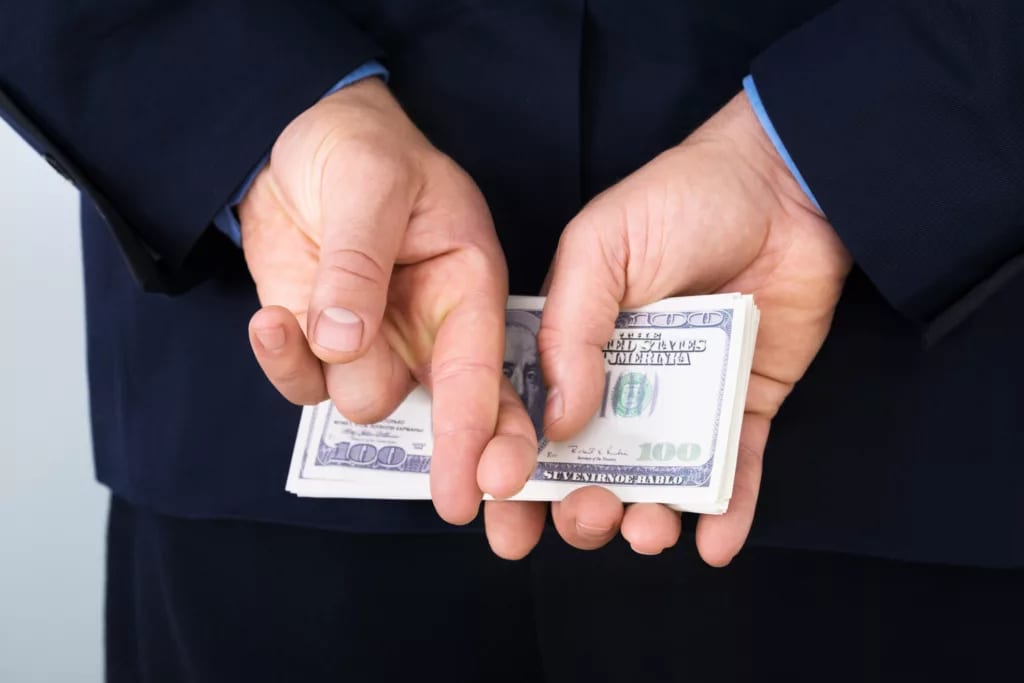 money behind back fingers crossed corporate tax getty.jpg