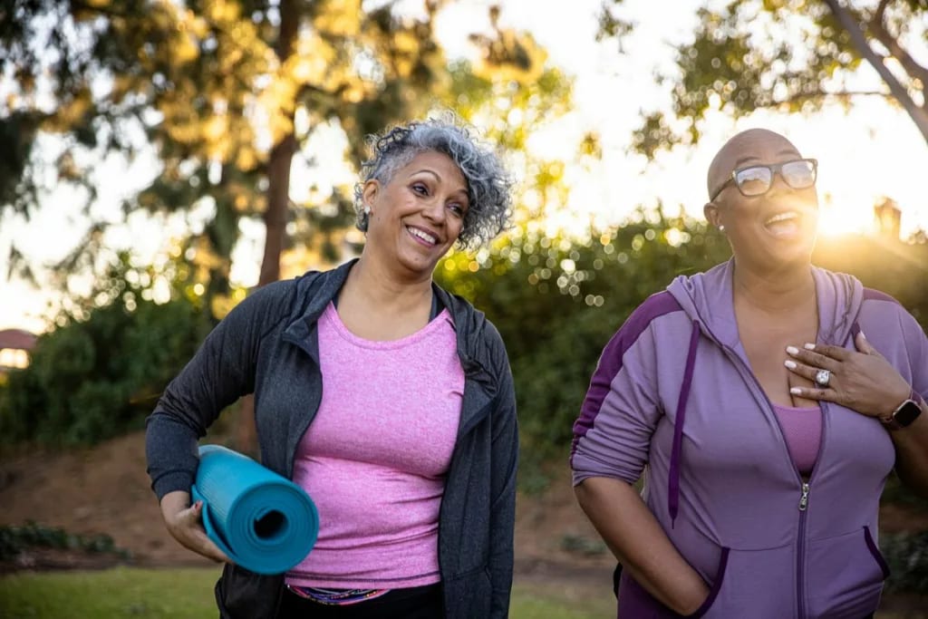 two middle age adults outdoors with yoga mats.width TkHNuQw.jpg