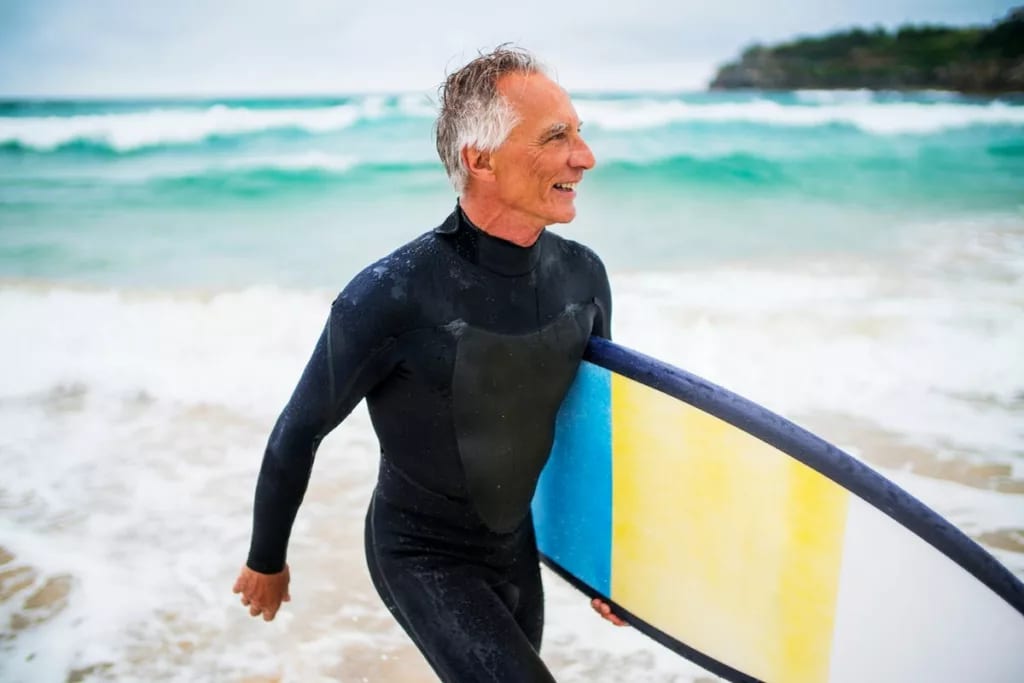 Person in wet suit carrying surf board in fro.width .jpg