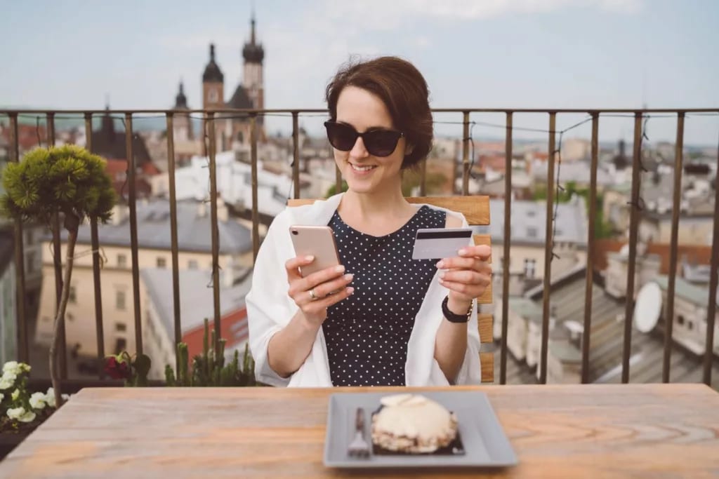 Woman holding her credit card and smiling whi.width iMSYz.jpg