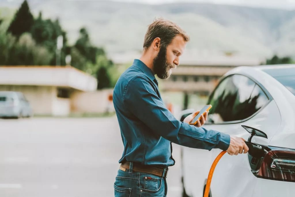 Person connecting their EV to power source wh.width .jpg
