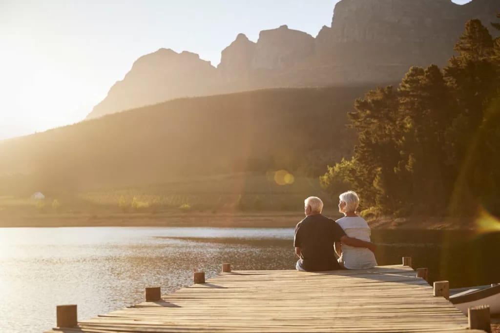 senior man and woman sitting at the end of a .width eBYYor.jpg