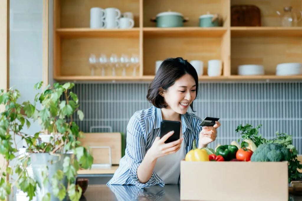 Young woman online shopping in kitchen JvCuFF.width .jpg