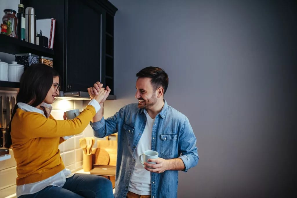 man and woman high five in a kitchen coupl.width eqGgmhV.jpg