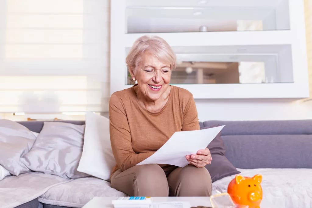 senior woman smiling reading document gettyimages .jpg