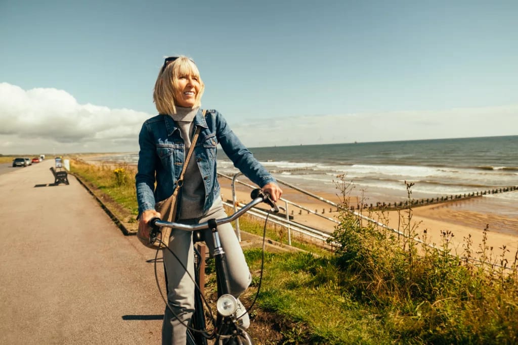 smiling person riding on bicycle by the ocean.jpg