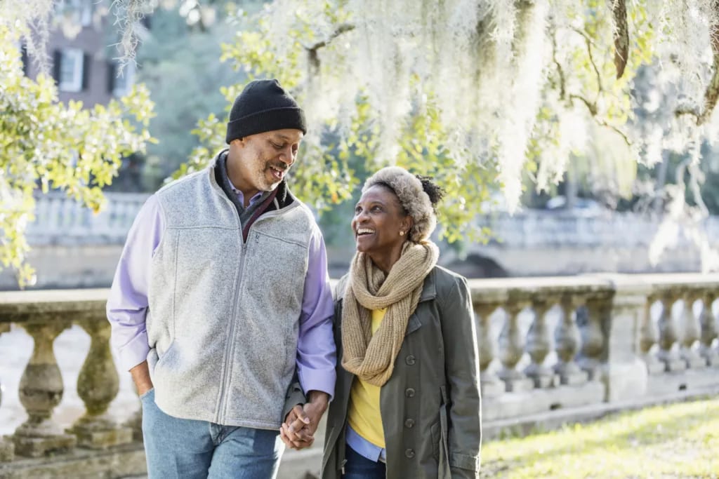two older people walking in the park holding handds.jpg