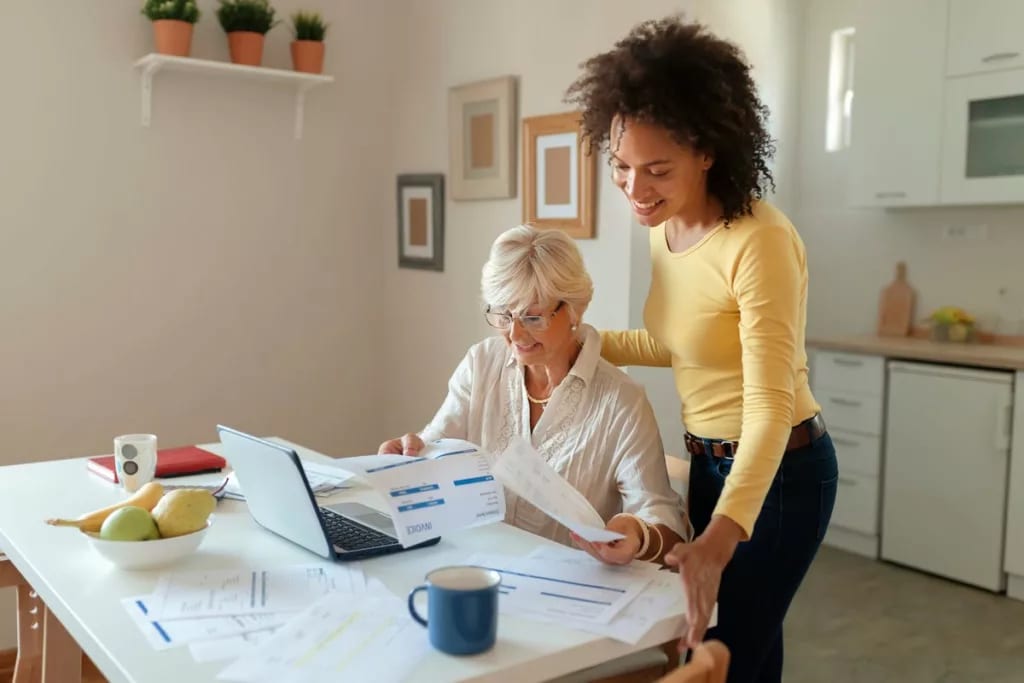 Two women look over finances in a kitchen nR.width .jpg