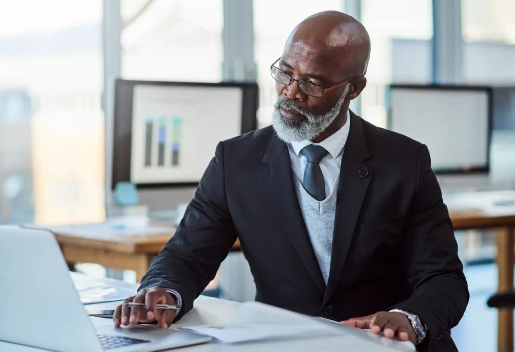 getty person in suit at desk laptop thoughtful thinking x cf.jpg