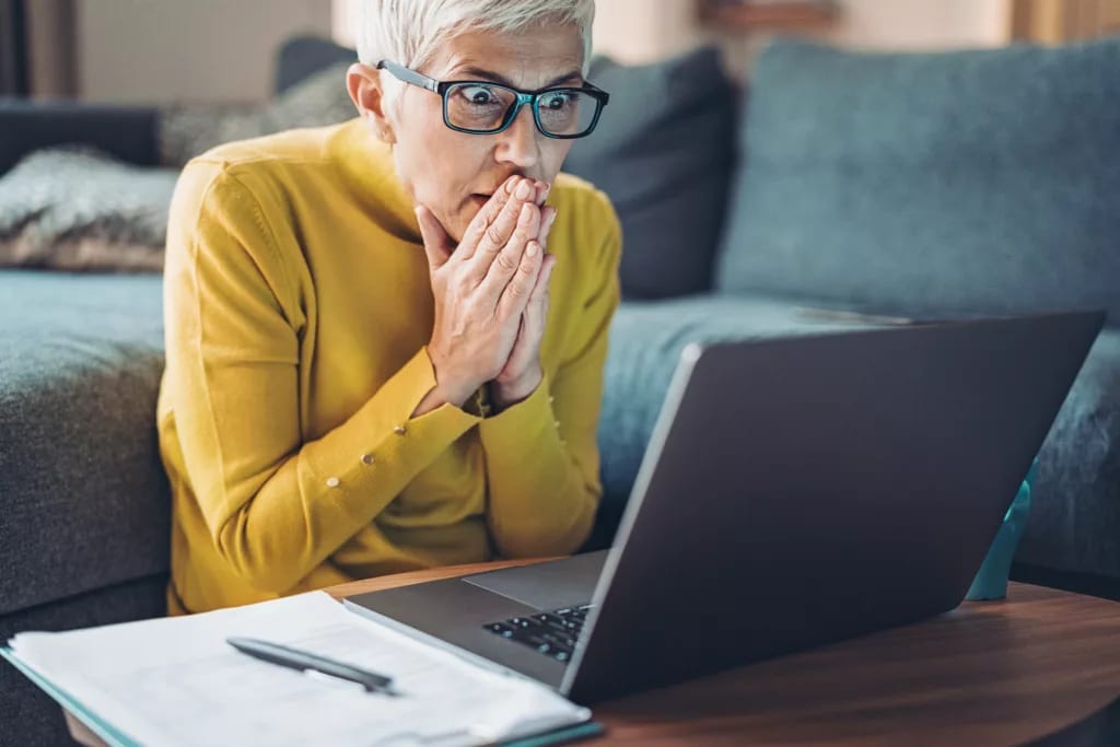 mature woman looking at computer in shock.jpg