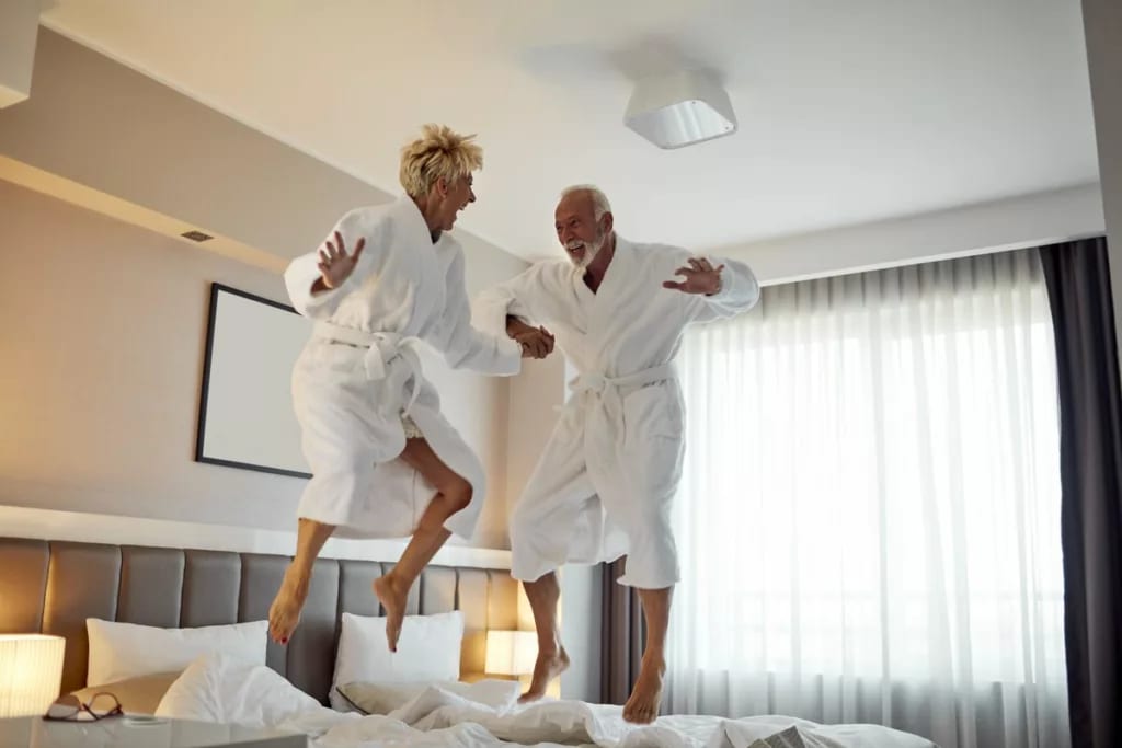 older couple jumping on beds pmgaTwT.width .jpg