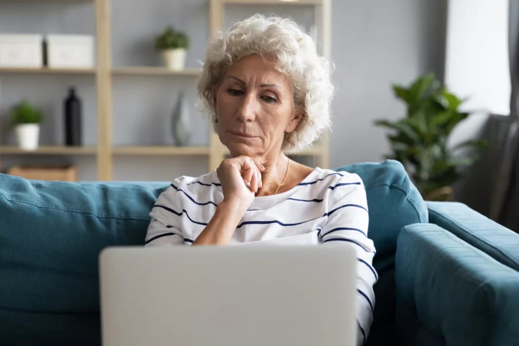 person with hand on chin looking at laptop.jpg