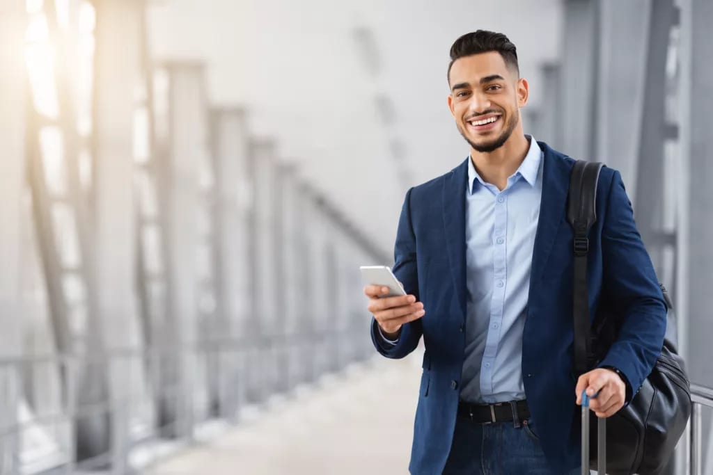 getty business traveler with shoulder bag smiling happy.jpg