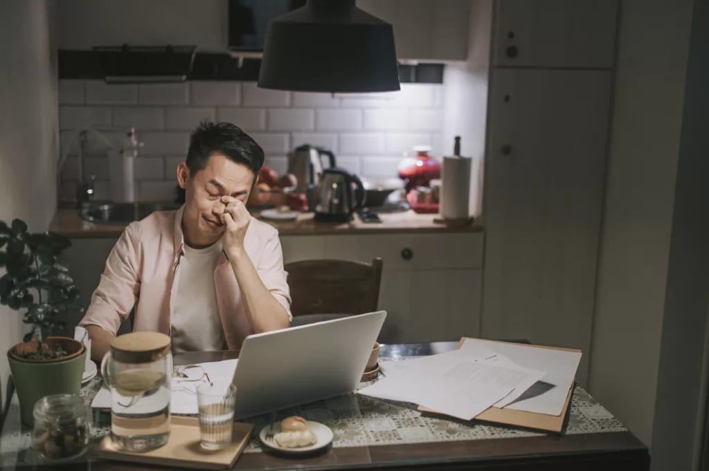 man with worried look in front of laptop .jpg