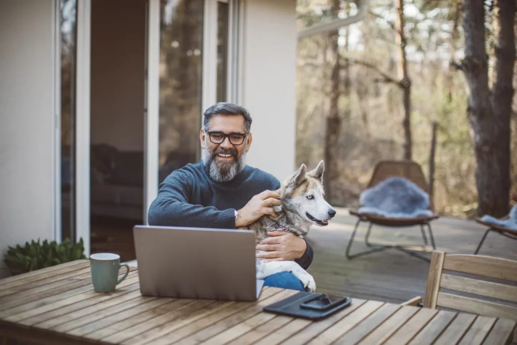 older man at laptop with dog gettyimages .jpg