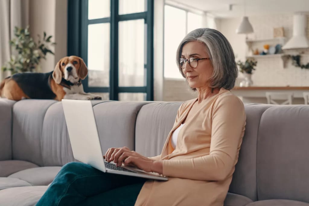 older woman laptop dog in background gettyimages .jpg