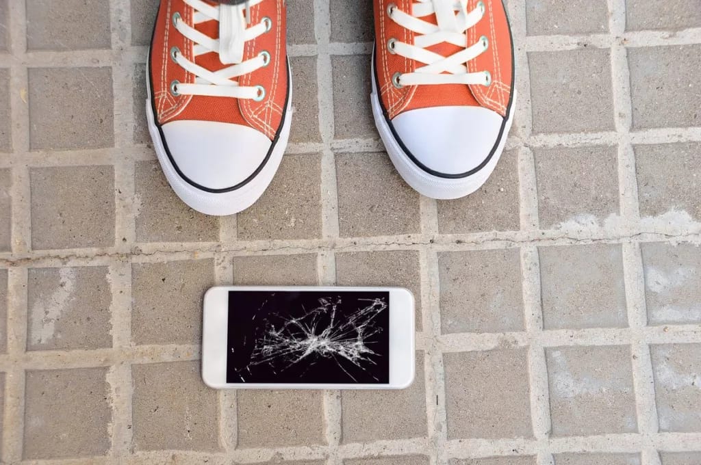Broken cell phone on ground.width .jpg