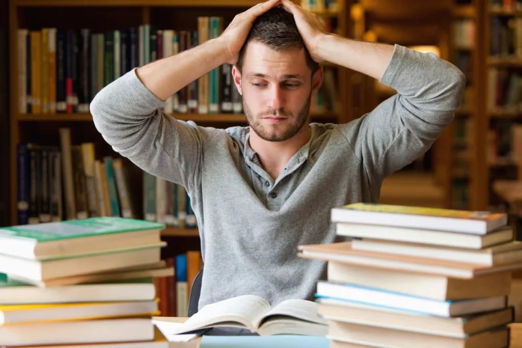 Male college student stressed books library S.width .jpg