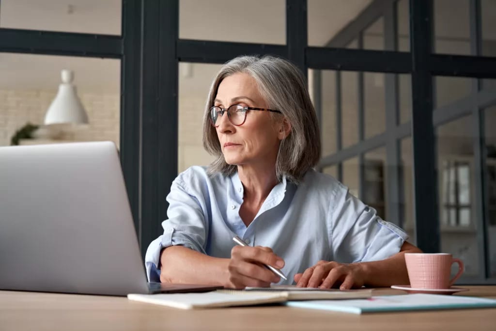 a person at a laptop holding a pen gettyimages .jpg
