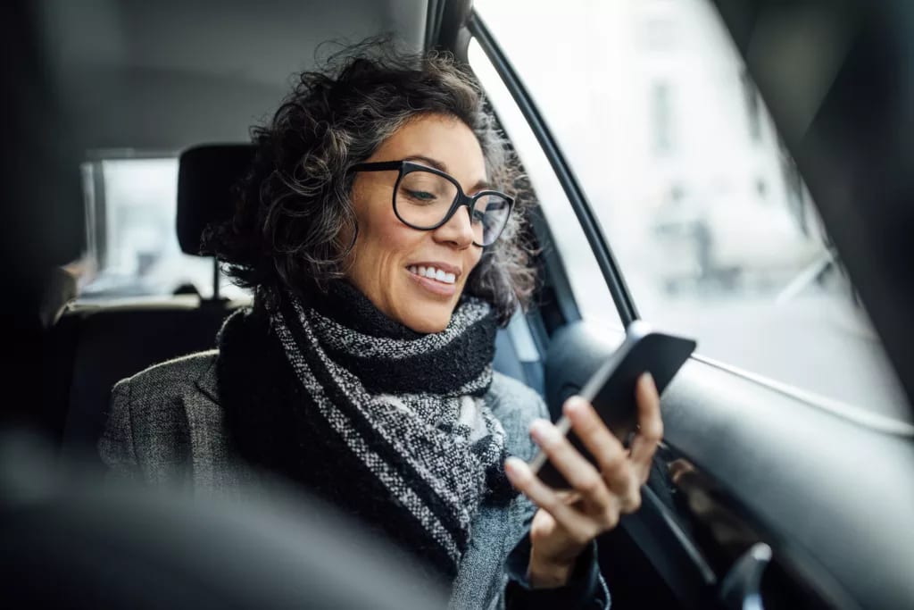 person sitting in a car looking at a phone.jpg