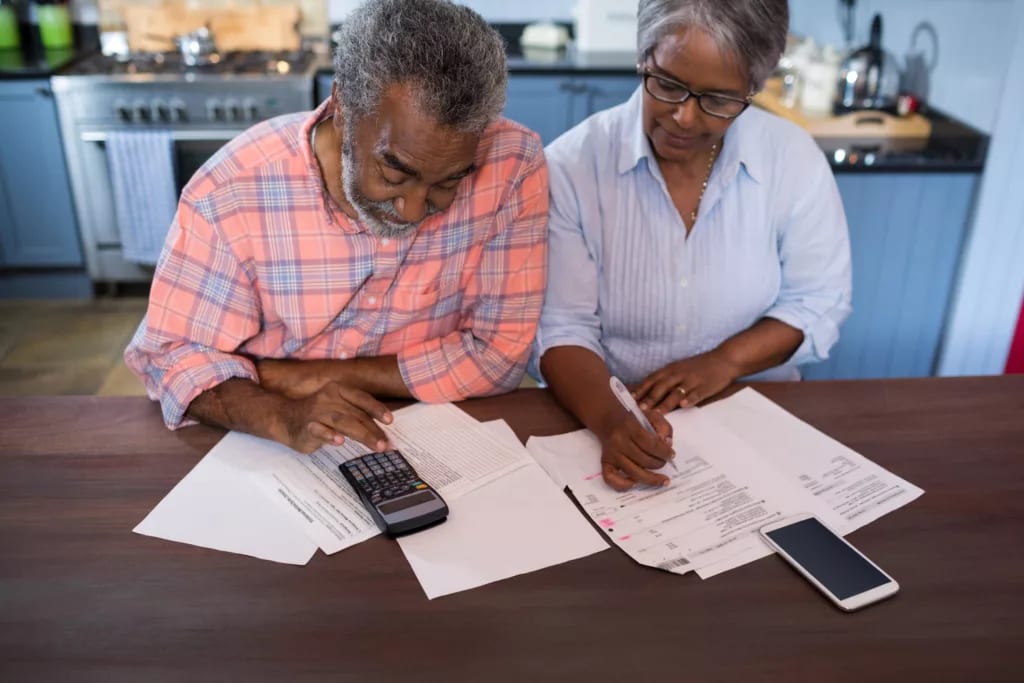 two people looking at documents and a calculator.jpg