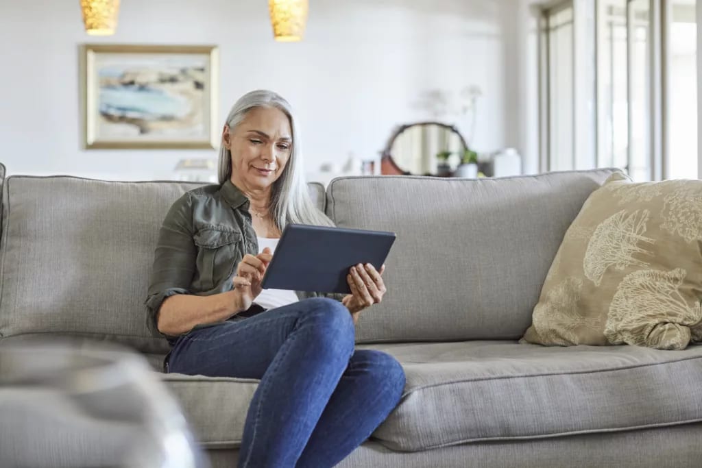 older woman couch tablet gettyimages .jpg