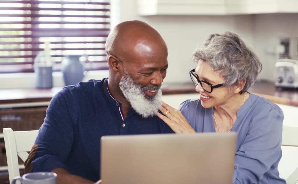 smiling mature couple using laptop at home.jpg